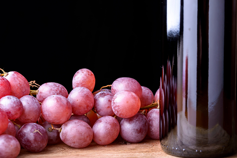 Uvas roxas e garrafa de vinho